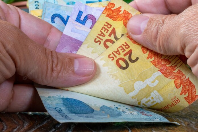 mao-de-homem-contando-dinheiro-brasileiro_146714-202